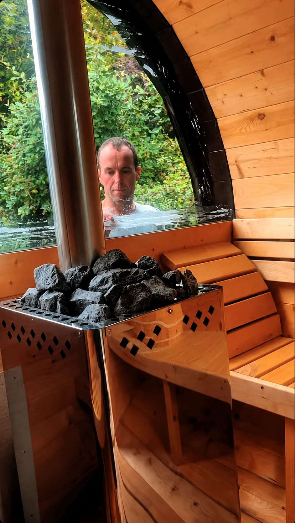 Inside the wood-fired sauna, with someone in a plunge pool visible through the window